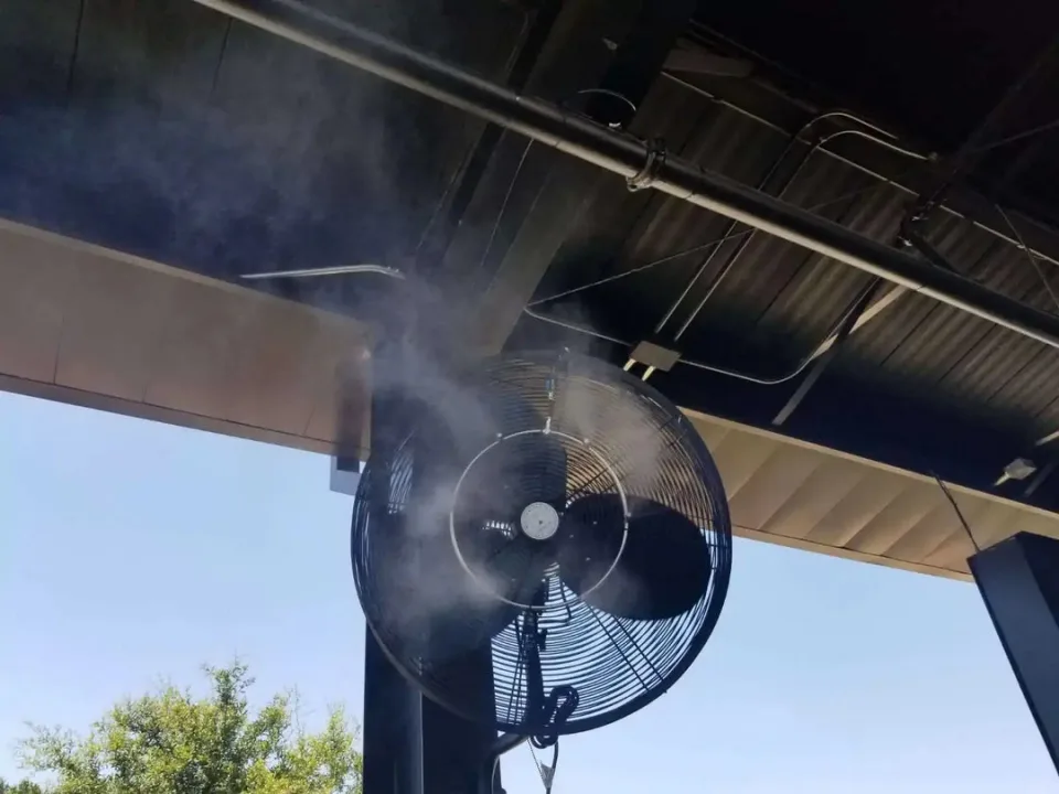Outdoor misting fan cooling a patio