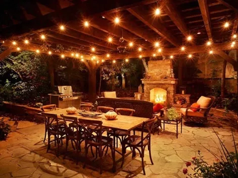 Warm string lights over a covered patio dining area
